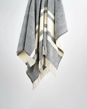 A striped grey wool throw blanket with fringes displayed against a light background