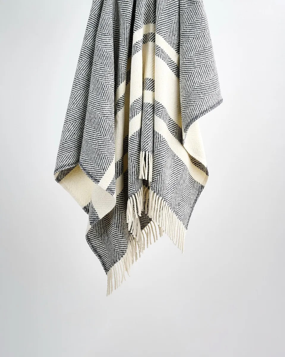A striped grey wool throw blanket with fringes displayed against a light background