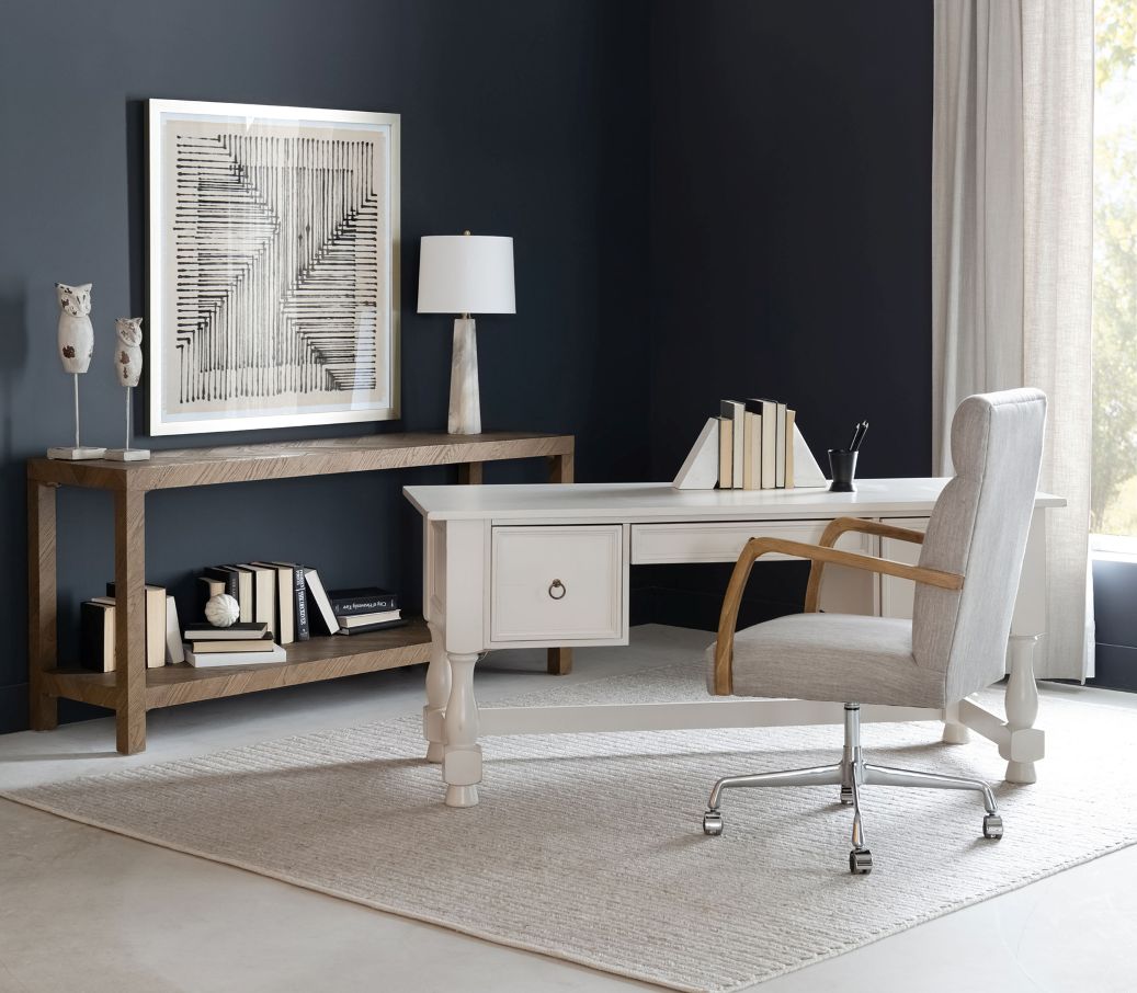 Modern office setup with desk, chair, and decor in a room with dark walls and a window.