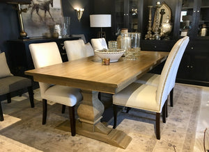 a beautiful wooden pedestal table  with chairs in a refined dining room in Canada