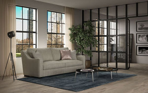 Modern living room with a gray comfortable sofa, round coffee table, and large windows.