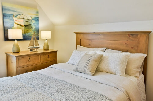 Bedroom set with wooden headboard, dresser, and decorative items.
